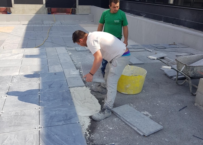 Plaatsen tegels in mortelbed van witte cement